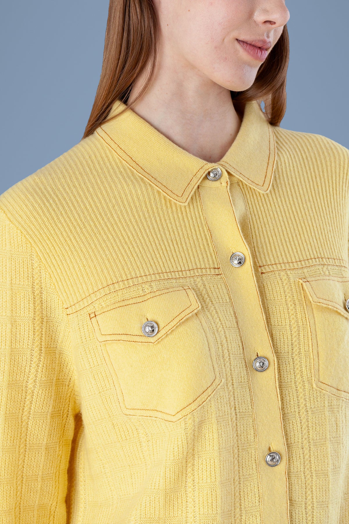 Close-up of pocket and buttons on yellow cashmere shirt