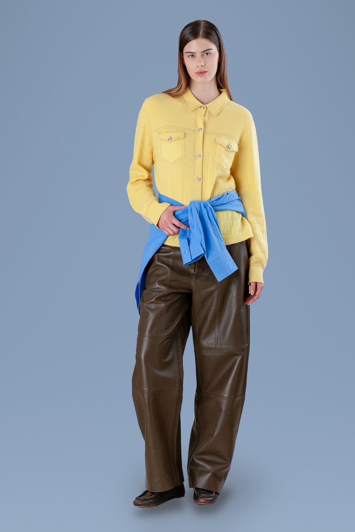 Yellow cashmere shirt worn with a blue sweater tied at the waist