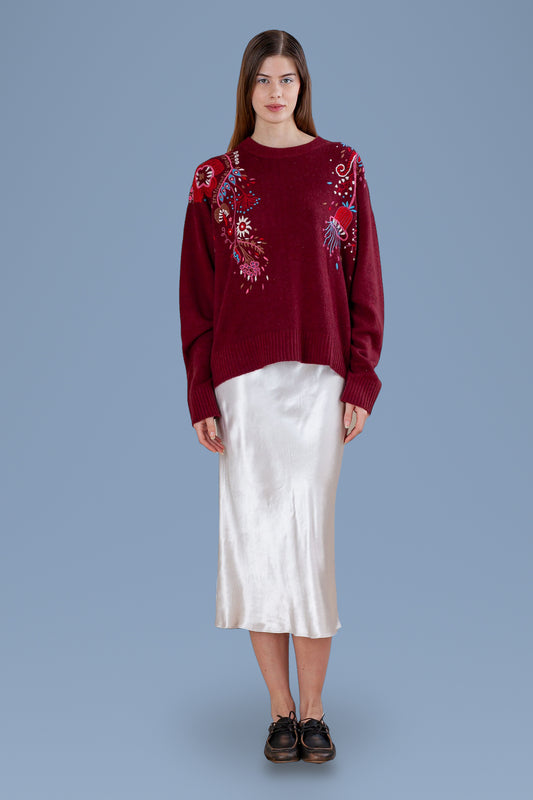 Burgundy hand-embroidered relaxed crew sweater, front view, worn with a white satin skirt