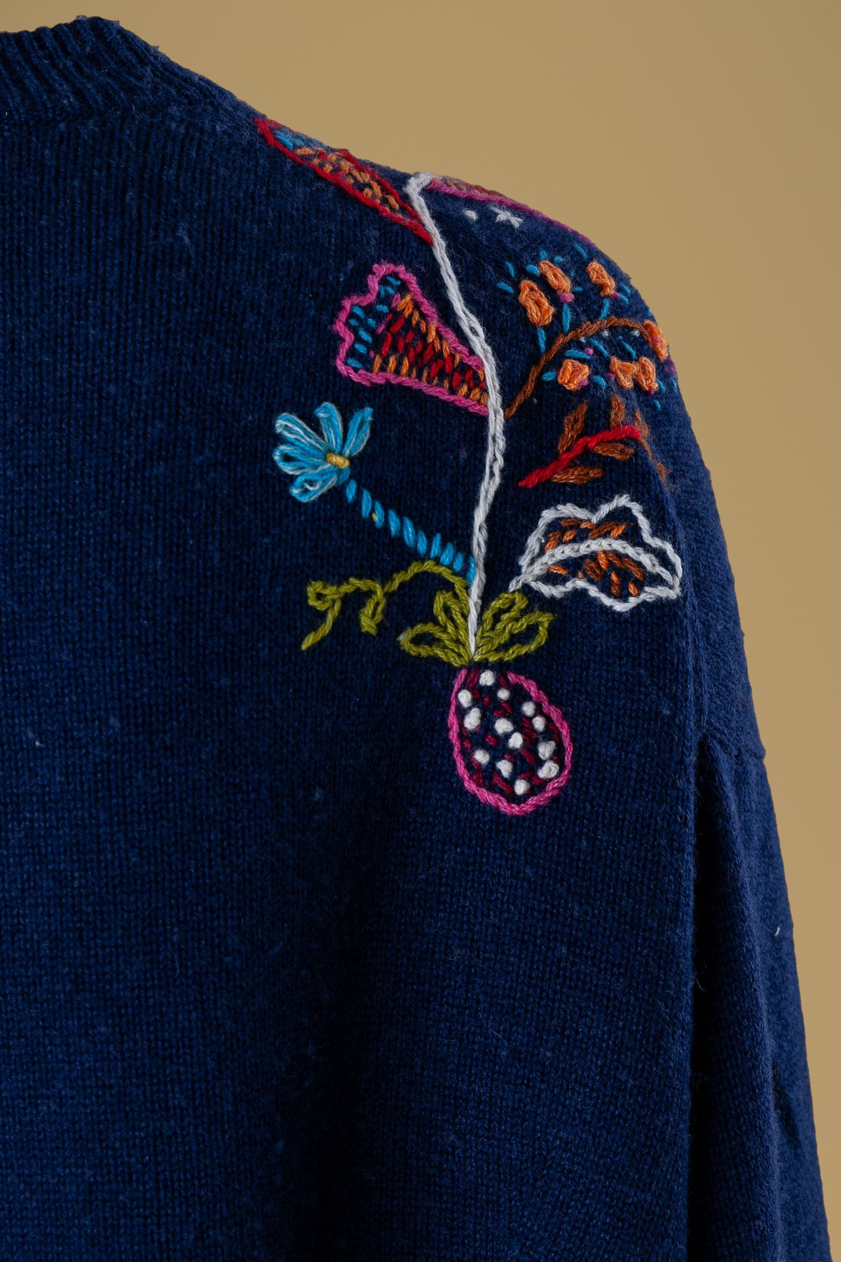 Close-up of the hand-embroidered bell flower on navy knit