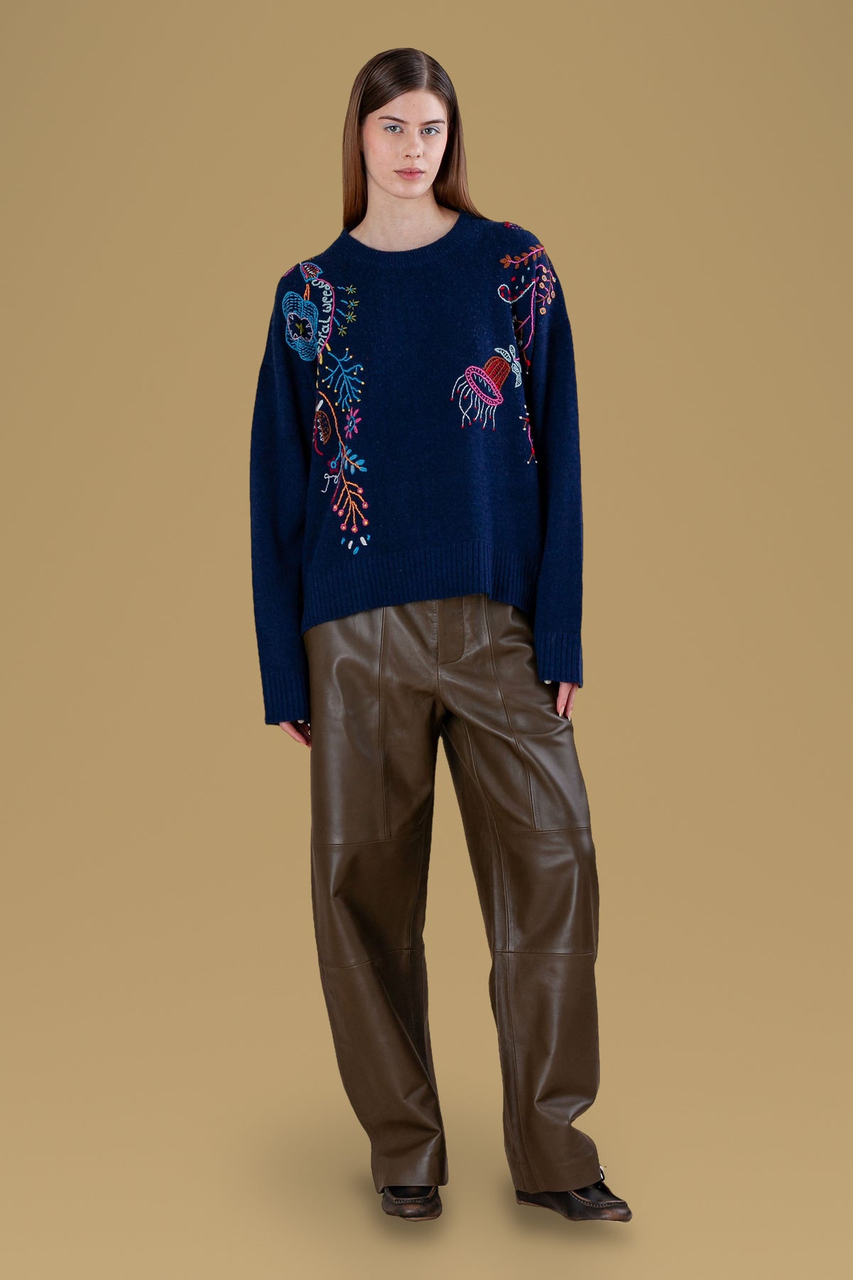 Navy hand-embroidered relaxed crew sweater, front view, worn with leather trousers
