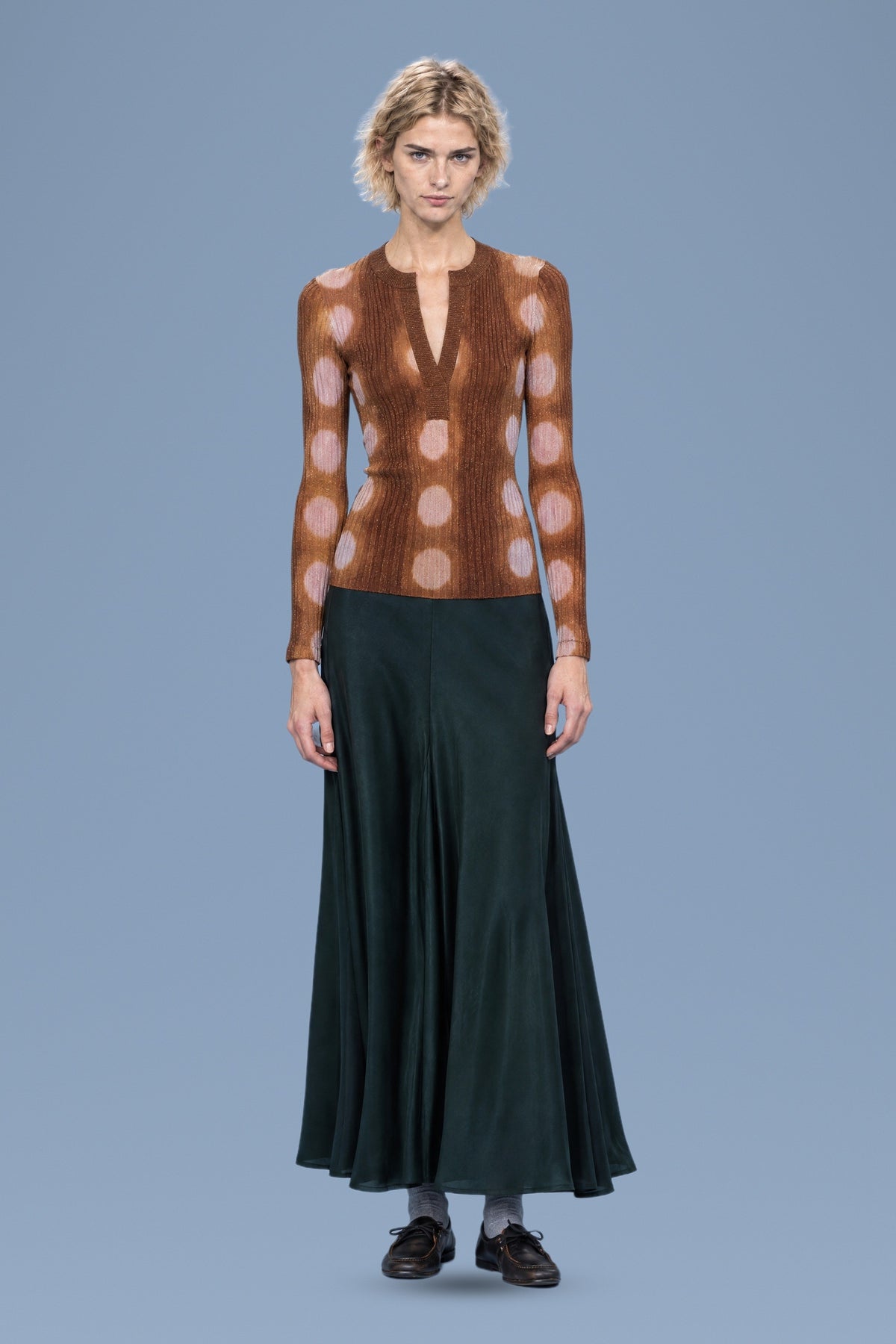 Brown ribbed henley sweater with pink tie-dye circles, front view, worn with a dark green skirt