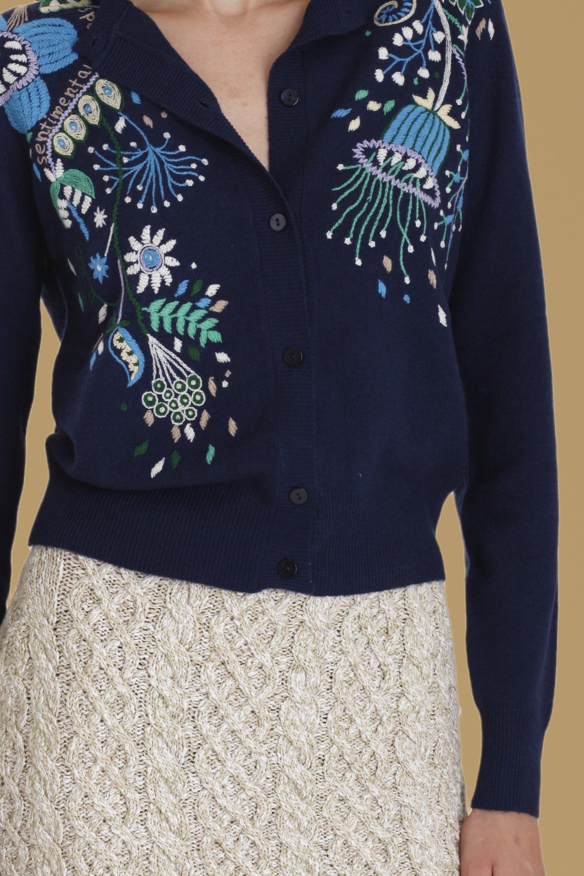 Close-up of the hand embroidery and buttons on the navy Rebecchina cardigan